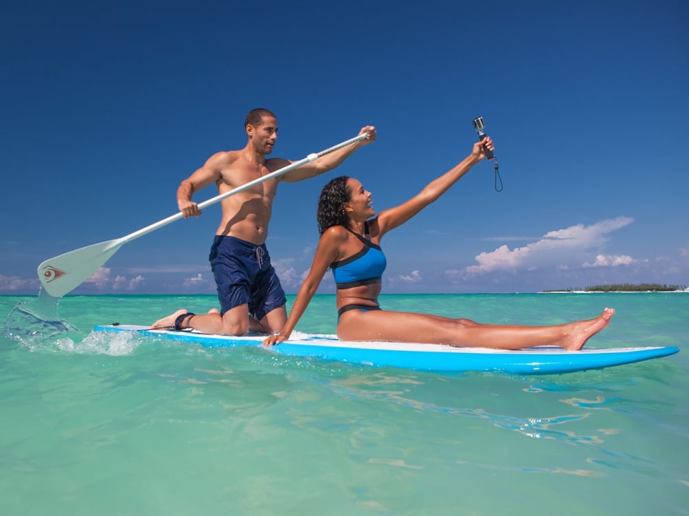 couple taking photos on paddle board